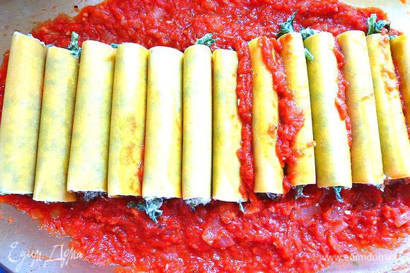 Заполнить трубочки смесью из шпината . Разложить каннелони плотно на томатный соус .