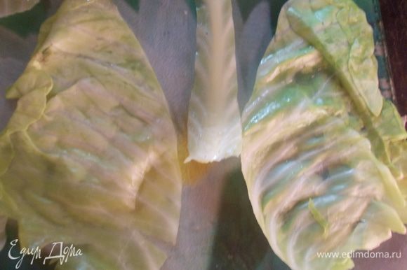 Подготовьте листья капусты для фарширования. Для этого большие листья разрежьте пополам, удалите толстое основание.