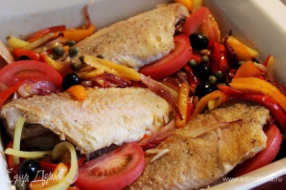 На рыбу выложить тушёные овощи, дольки помидоров, маслины и каперсы. Запекать рыбу при 180*С около 8-10 минут.