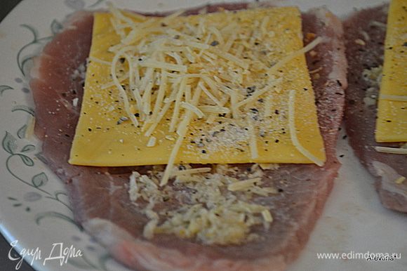 Поверх стейков выложить сыр пластинками, затем сыр Пармезан. Посыпать чесночной и луковой специей. Нет в продаже этих специй используйте натуральный лук и чеснок, мелко покрошив.