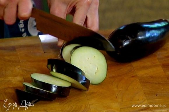 Баклажан нарезать толстыми кружками, выложить в миску, влить 2 ст. ложки оливкового масла и все перемешать.