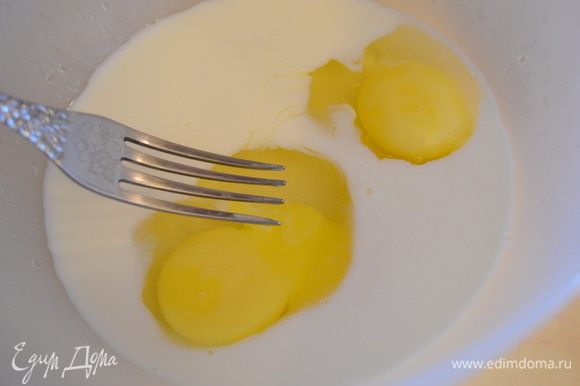 Вилочкой взбить яйца со сливками, сливочным масло и половиной натертого сыра.