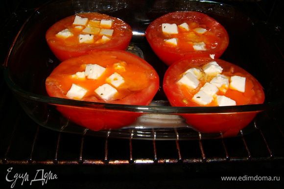 Порезать кубиками брынзу и щедро положить сверху в каждую половинку помидоров. Посолить, поперчить, добавить мелко нарезанный чеснок.