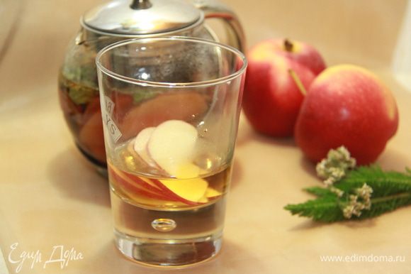 В стеклянные бокалы для глинтвейна положить по 3 ломтика яблока, налить по 50 мл горячего яблочного сока, долить настоявшимся пряным чаем.