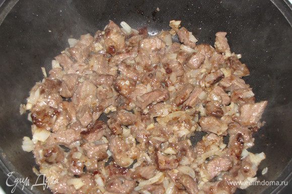 Добавить к мясу мелко нарезанный лук и чеснок и жарить еще 3 минуты. Выложить мясо с луком в тарелку.
