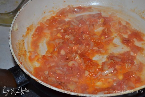 Лук и чеснок мелко нарезать, спасеровать. Добавить рубленые томаты, довести до кипения и немного уварить.