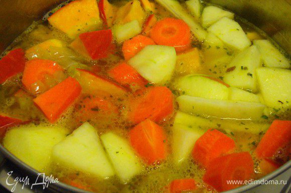 В кастрюлю погружаем тыкву, яблоко, морковь, обжаренный лук и заливаем овощным бульоном. Слегка подсаливаем.