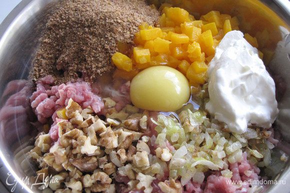 К мясному фаршу добавьте жареный лук с чесноком, тыкву, орехи, панировочные сухари, сметану, яйцо. Посолите и поперчите. Хорошо перемешайте.