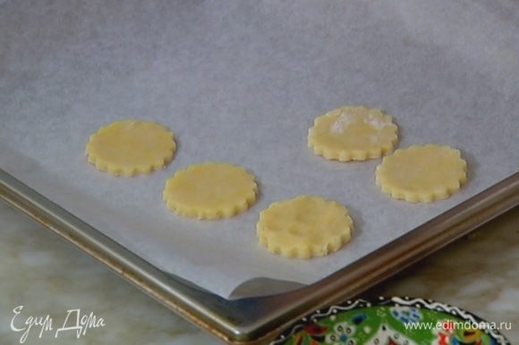 Противень выстелить бумагой для выпечки, выложить сырные кружки и отправить в разогретую духовку на 10 минут.