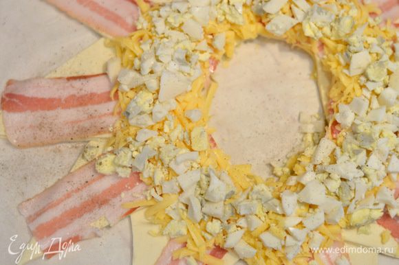 Затем поверх сыра выложить отварные и мелко порубленные яйца, засыпать остальным сыром.