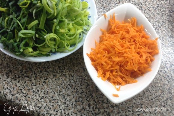 Натрите морковь. Нарежьте зеленую часть лука колечками (оставшуюся часть можно заморозить и использовать, например, в овощной лазанье).