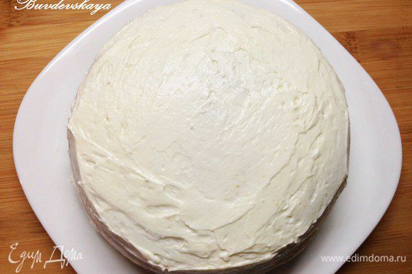 Вынимаем торт из холодильника, аккуратно вытаскиваем бумагу для выпечки из под низа. Наносим крем на верхнюю и боковые части торта.
