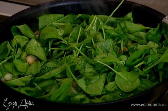 Добавить зеленый лук и шпинат, еще немного обжарить, затем уменьшить огонь и готовить 2–3 минуты, чтобы шпинат стал мягким.