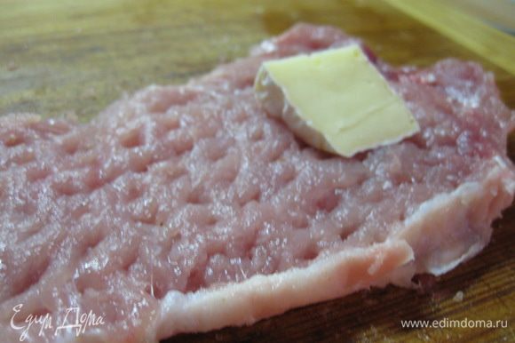 Мясо нарезать на битки толщиной около 1,5 см и хорошенько отбить, посолить и поперчить. На одну половину каждого отбитого куска свинины положить по ломтику сыра "Камамбер", затем накрыть второй половиной.