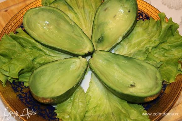 Лодочки из авокадо выложить на листовой салат и наполнить их начинкой. Украсить физалисом, креветками и половинками перепелиных яиц.