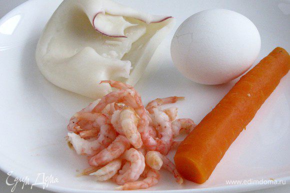 Отварить кальмары и креветки в подсоленной воде. Отварить яйца и морковь. Кальмары нарезать очень тонкой соломкой.