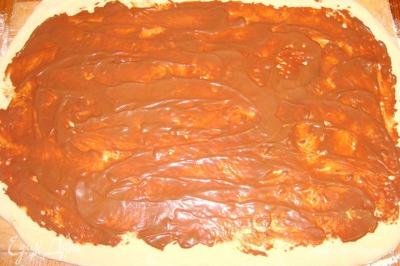 Шоколадные конфеты типа "Маски" и шоколад растопить на водяной бане, смешать со сметаной и сахарной пудрой. Остудить. 1/2 частью смазать тесто, оставляя края по 1.5-2 см.
