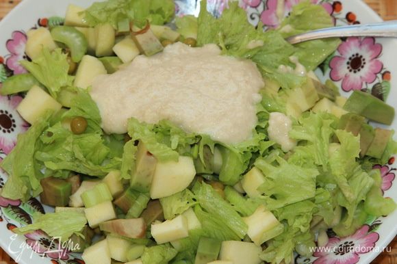 К нарезанным ингредиентам рвем листья салата и добавляем 2 столовые ложки заправки.