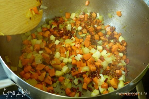 Обжаренную колбасу выкладываем на тарелку. Лук, морковь и чеснок нарезаем средним кубиком. На вытопившемся жире обжариваем лук и морковь до золотистого цвета. Добавляем тмин, паприку и чеснок, обжариваем все еще пару минут.