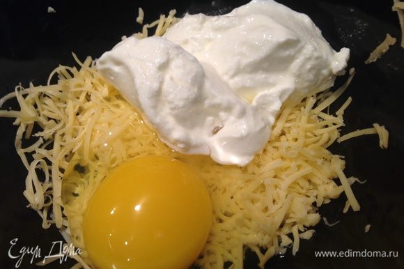 Сыр (можно использовать любой твердый сыр, у меня Российский) натереть, добавить яйцо и сметану, хорошо смешать.