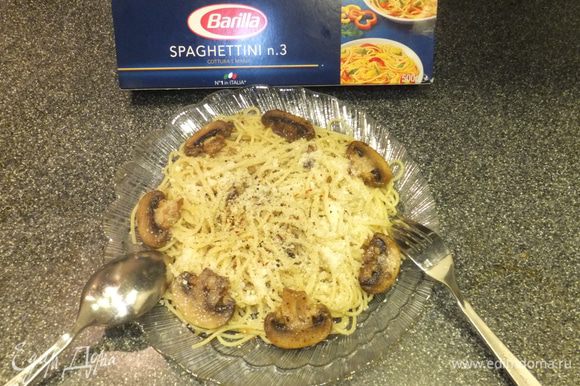 Выложите на тарелку спагетти, полейте соусом. Положите целые грибочки и посыпьте тертым пармезаном.