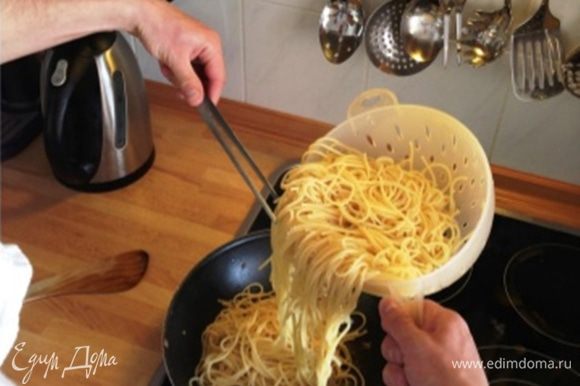Спагетти выкладываем на сковороду и помешиваем на малом огне.