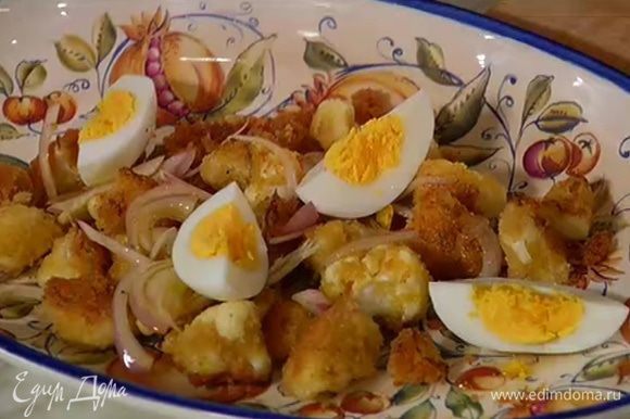 На большое блюдо выложить горячую обжаренную капусту, полить заправкой с луком, сверху выложить разрезанное яйцо.