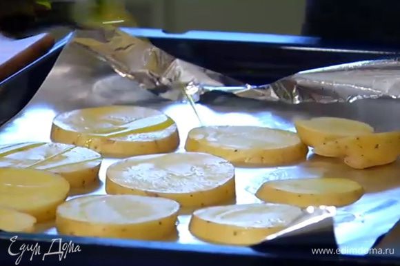 Противень выстелить фольгой, выложить картофель, сбрызнуть 1–2 ст. ложками оливкового масла и отправить под гриль на 10 минут.