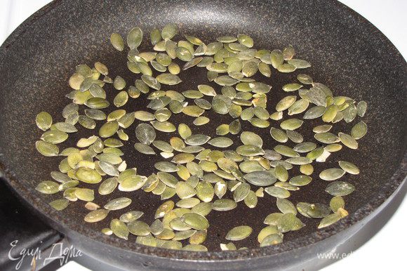 На сухой сковороде обжарьте тыквенные семечки до золотистого цвета.