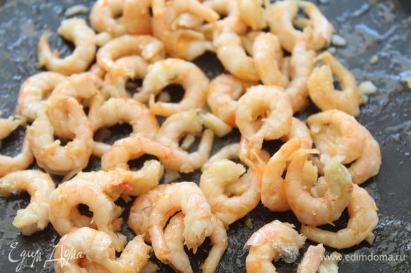 Если креветки замороженные, обдать их горячей водой, выложить на сковороду вместе с оливковым маслом и чесноком. Обжарить до золотистого цвета.