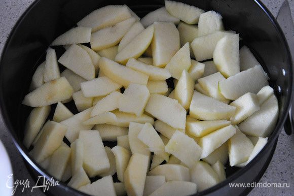 Яблоки для начинки нарезать ломтиками и уложить в форму в произвольном порядке.