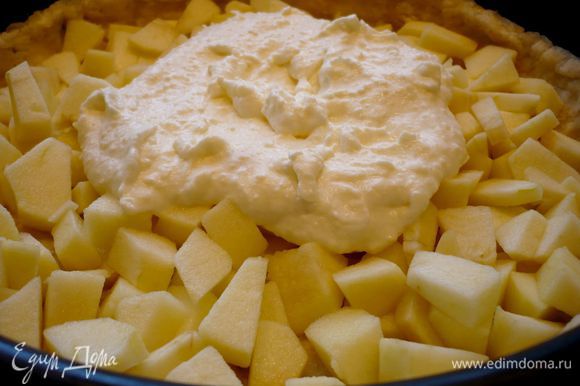 Теперь на тесто выложим половину яблок. Сверху выложим чуть меньше половины сливочной заливки, распределим заливку по яблокам.