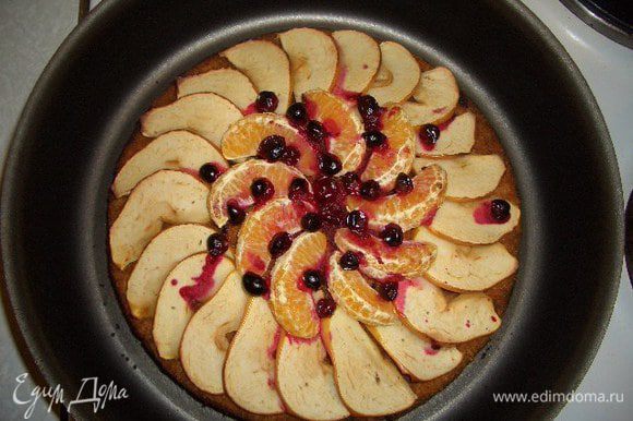 Достать пирог и украсить его тонко нарезанным яблоком, дольками мандарина и клюквой. Поставить снова в духовку на 10-15 минут. Готовый пирог немного остудить, посыпать сахарной пудрой перемешанной с корицей.