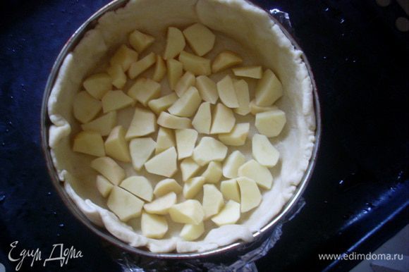 Отделить от теста 2/3 объема и раскатать круглую лепешку. Сложить лепешку в форму или сковороду для запекания, так, чтобы тесто доходило до краев бортиков. Разложить на дно половину объема картофеля.