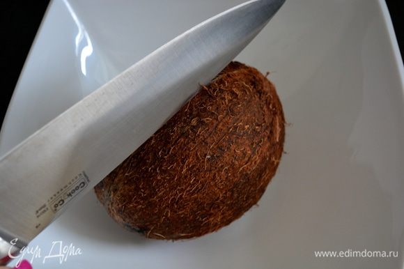 Дальше пытаемся добраться до середины кокоса. Для этого берем самый большой нож и "тупой" стороной наносим удар по шву вдоль всего кокоса. Спустя 2-3 мин кокос даст трещину.