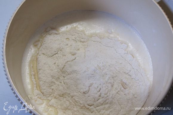 В теплое молоко добавить взбитые с сахаром и солью яйца. Всыпать половину муки, сухие дрожжи, размешать.