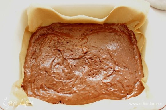Дно формы застелить бумагой для выпечки. Смазать бумагу и бока формы маслом. Выложить шоколадное тесто в форму и разровнять его.