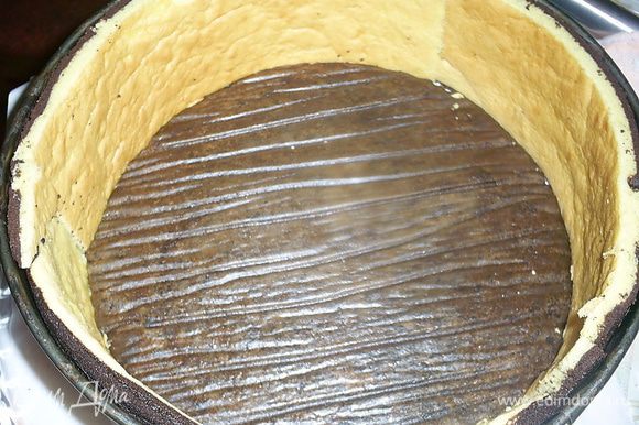 В форму кладем один шоколадный бисквит наверх той стороной, которая была на пергаменте. Устанавливаем бортики из бисквита.