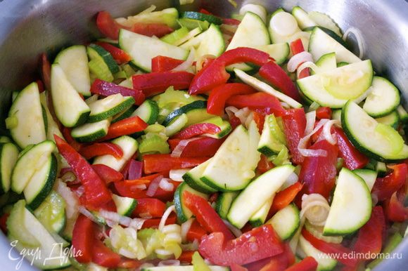 Нагреть духовку до 200 С. Разогреть оливковое масло в большой сковороде и обжарить сельдерей, красный перец, кабачок и зеленый лук на умеренном огне около 5 минут.