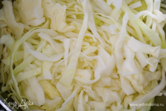 Приготовим гарнир из капусты. Нашинковать капусту. В большой сковороде разогреть 60 г сливочного масла и положить капусту. Перемешать, чтобы она как следует покрылась маслом.