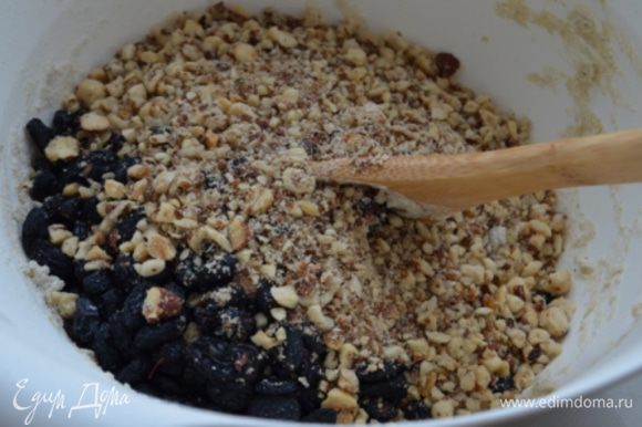 В тесто добавить изюм и орехи и вмешать их руками.
