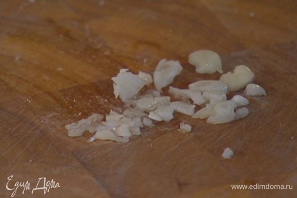 Чеснок почистить, раздавить плоской стороной ножа, посыпать щепоткой соли и растереть.