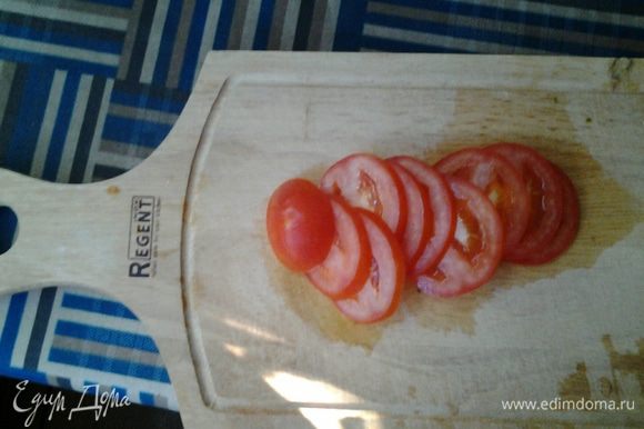 Пока омлет запекается, режем помидор тонкими колечками.
