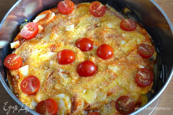 Выложить сырный соус на поверхность запеканки. Сверху украсить разрезанными пополам помидорками и дольками яйца. Выпекать в духовке разогретой до 180 С 10-15 минут.