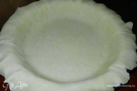 Достать тесто из холодильника. Первую половинку раскатать на посыпанной мукой рабочей поверхности и разместить на смазанную маслом форму для пирога.