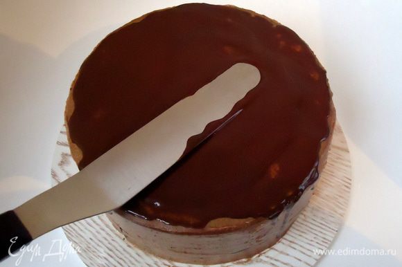 Шоколад растопить с двумя столовыми ложками растительного масла, немного остудить и нанести на верхний корж торта.