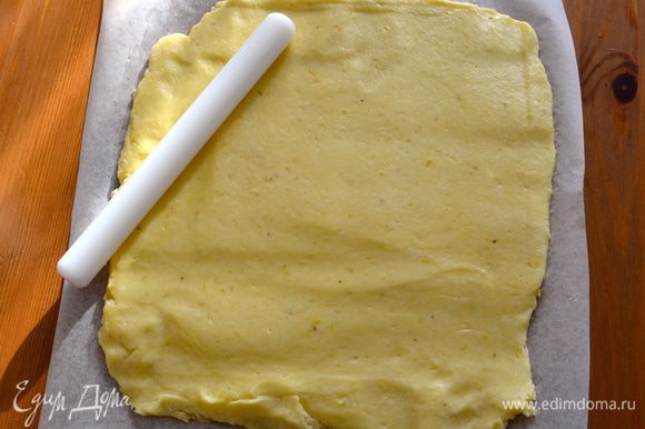 На рабочий стол положить лист пекарской бумаги. Смазать бумагу растопленным сливочным маслом и присыпать слегка мукой. Выложить картофельное "тесто" и раскатать его в пласт равномерной толщины размером 30 Х 25 см.