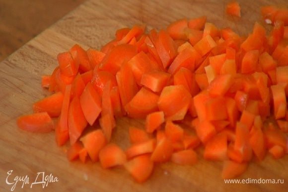 Морковь почистить, нарезать небольшими кусочками, выложить к луку с чесноком и обжаривать на медленном огне.