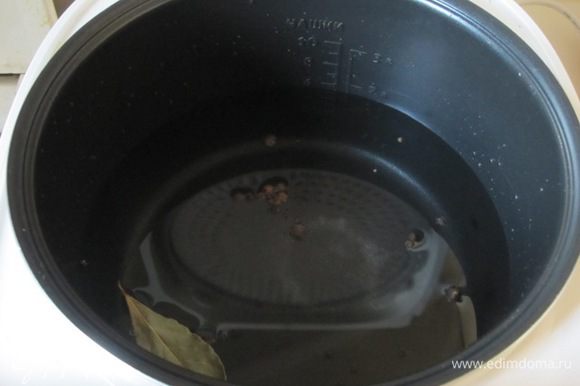 В чашу мультиварки налить воду. Посолить, добавить лавровый лист, черный и душистый перец горошком.