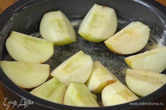 Форму для выпечки смазать оставшимся сливочным маслом, присыпать оставшимся сахаром, разложить яблоки срезами вверх, а сверху выложить тесто.
